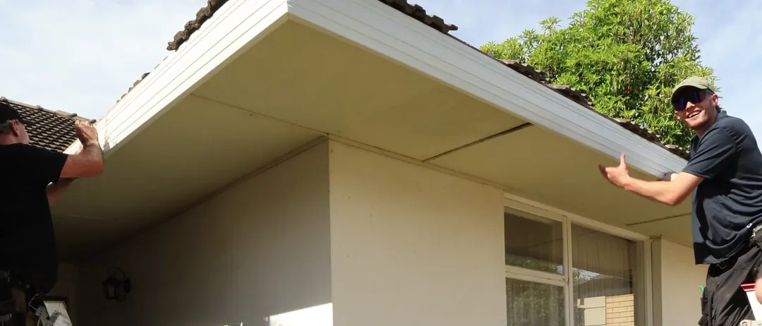 Two of the crew fitting new fascia on a client's home
