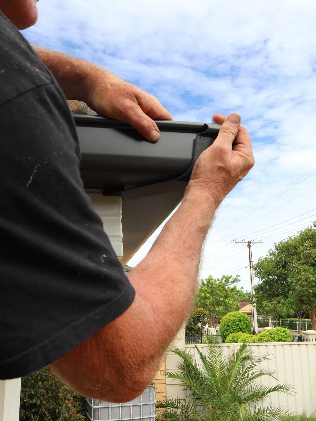 Clipping a length of new gutter into place by hand