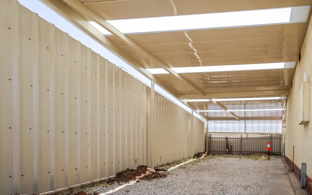 Inside a long carport down the side of a Woodville house, skylight sheets overhead