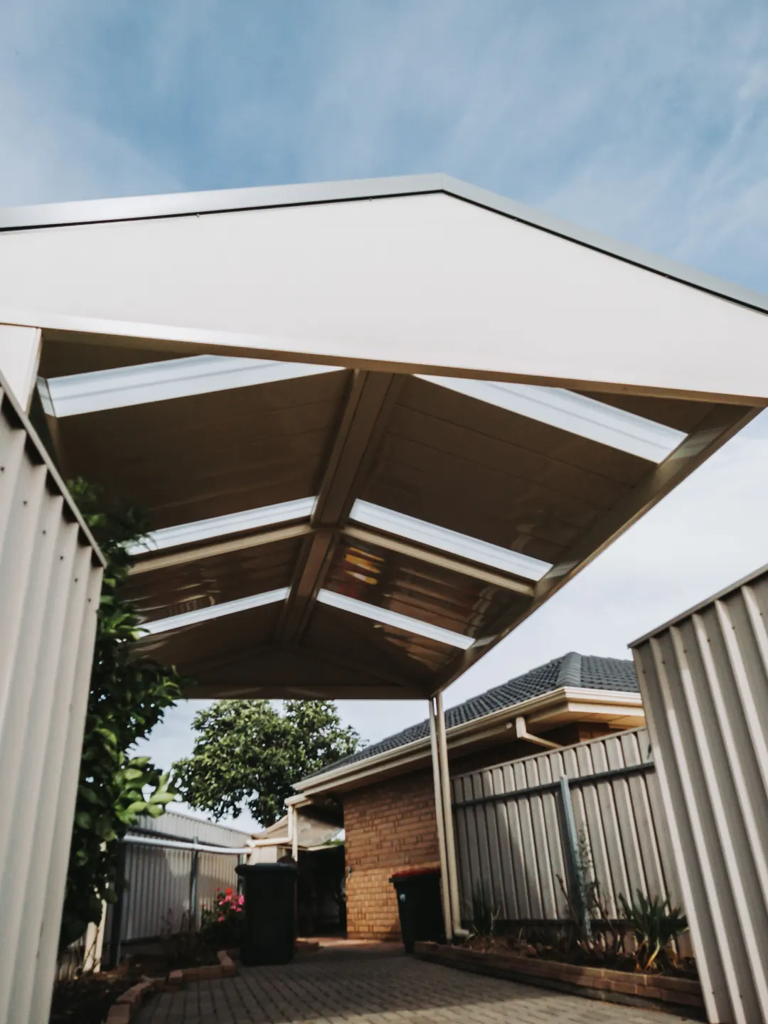 Looking up into a new gable carport with skylight panels