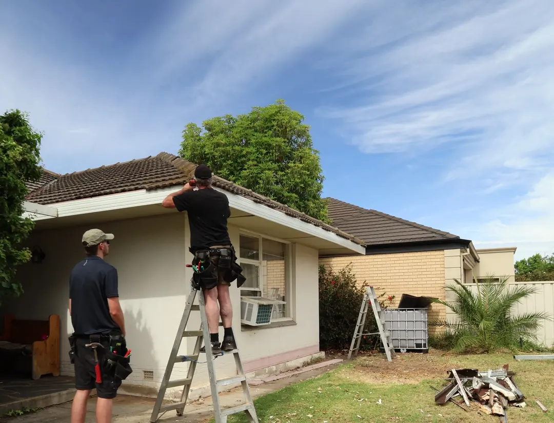 Two of the Built For Life crew replacing gutters and fascia on a tiled-roof Adelaide home