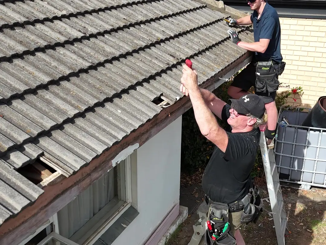 The crew on ladders taking the old gutter and fascia off