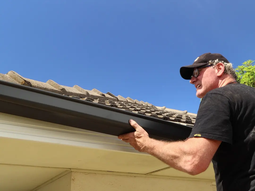 Lifting a new Colorbond gutter onto its brackets
