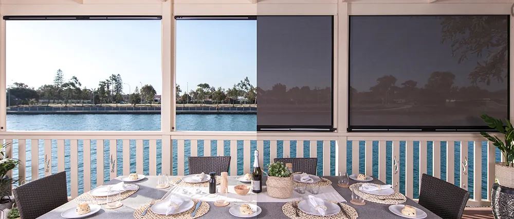 Ziptrak® outdoor blinds half down on a waterfront alfresco area (product photo: Ziptrak)